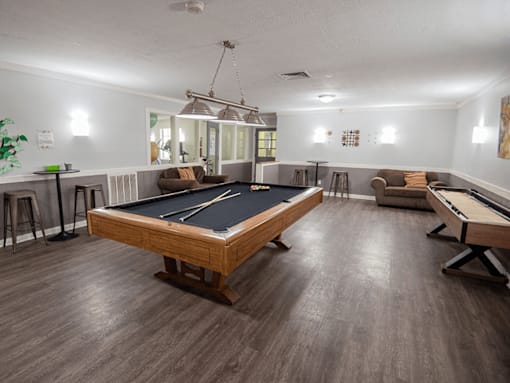A room with a pool table and a billiard table.