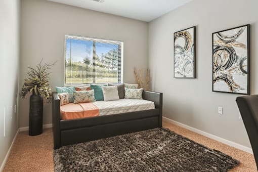 A bedroom with a large bed and two framed artworks on the wall.