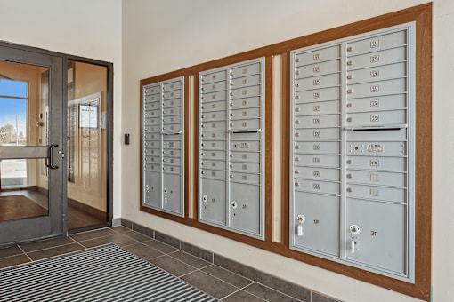 A row of mailboxes are lined up on a wall.