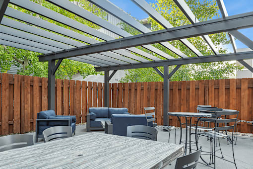 A patio with a table and chairs under a roof.