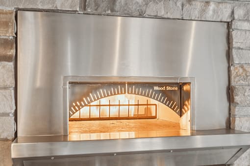 A wood stove with a metal frame and a glass door.