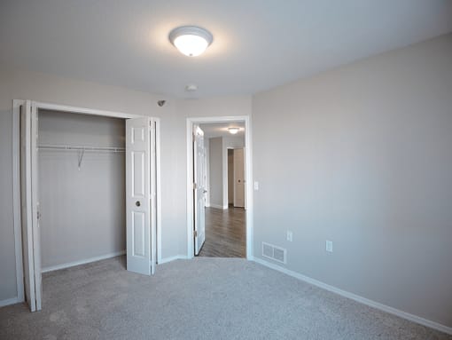 a bedroom with a closet and a closet door open