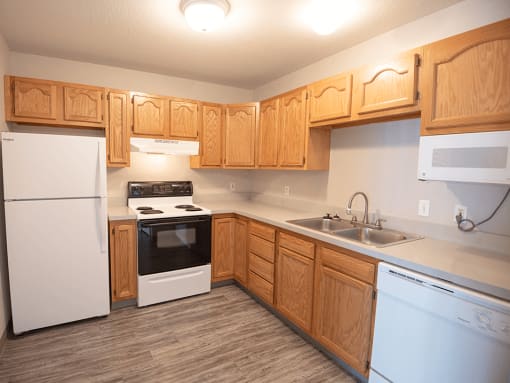 a kitchen with white appliances and wooden cabinets