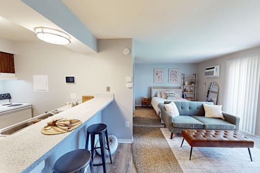 A kitchen with a bar area and a living room.