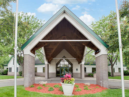 A building with a green roof and a white pillar in front of it.