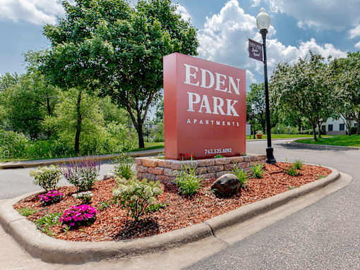 A sign for Eden Park Apartments is displayed in front of a landscaped area.