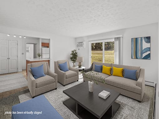 A living room with a grey couch, two armchairs and a coffee table.