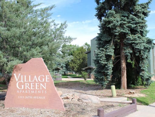a sign that reads village green apartments