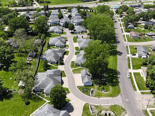A residential area with houses and a curved road.