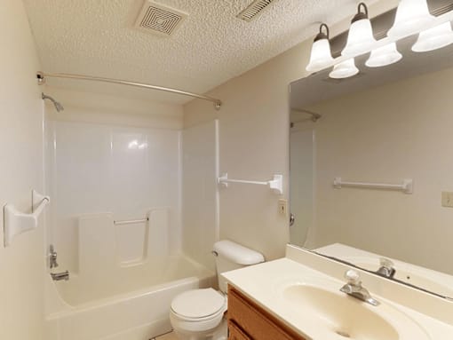 A white bathroom with a toilet, sink, and bathtub.