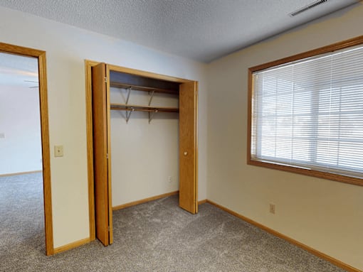 A room with a closet and a window.