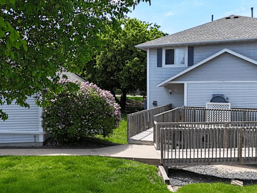 A house with a grey roof and a white fence.