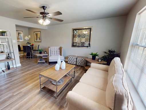 A living room with a white couch and a wooden coffee table.