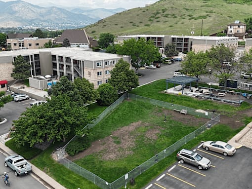 A parking lot with cars and a building in the background.