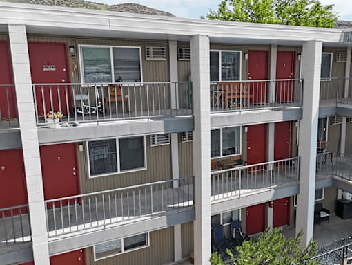 Apartment building with red doors and balconies.