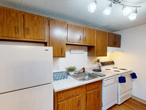 A kitchen with wooden cabinets and white appliances.