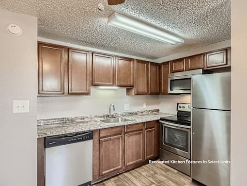 A kitchen with brown cabinets and stainless steel appliances.