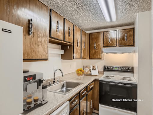 A kitchen with wooden cabinets and a white fridge.
