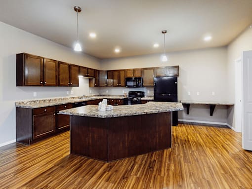 A kitchen with wooden floors and a central island.