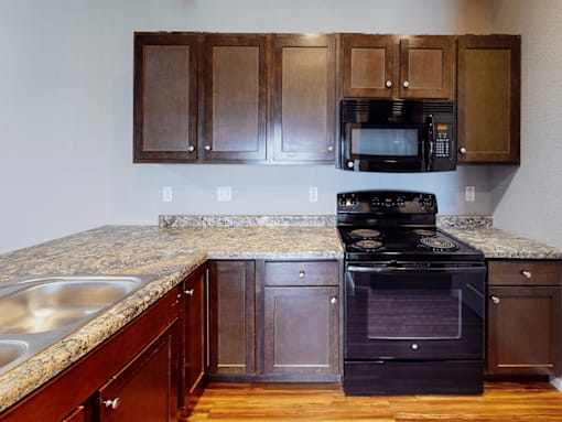 A kitchen with a black oven and microwave.