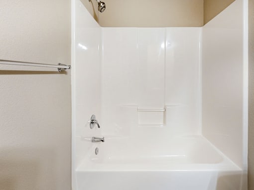 A white bathroom with a tub and a shower.