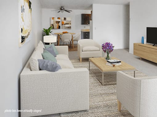 A living room with a couch, chairs, and a coffee table.