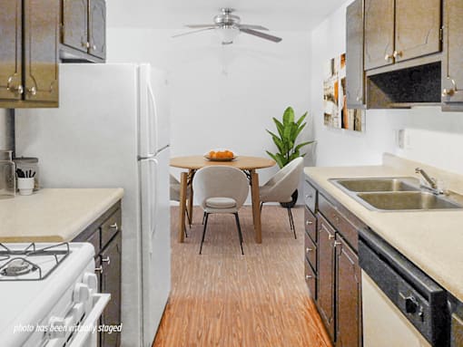 A kitchen with a table and chairs in the middle.