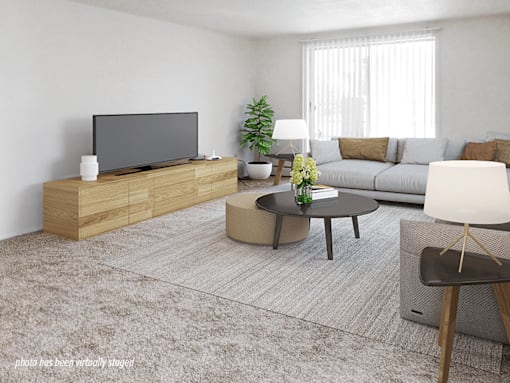 A modern living room with a flat screen TV, a coffee table, and a couch.