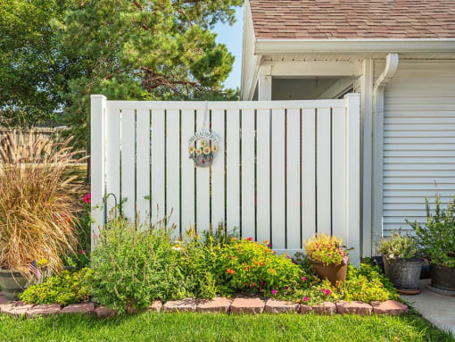 a house with a pink and white fence and a garden