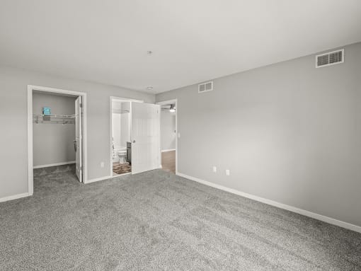 primary bedroom in apartment with walk-in closet and bathroom
