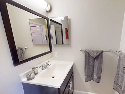A bathroom with a white sink and a mirror above it.