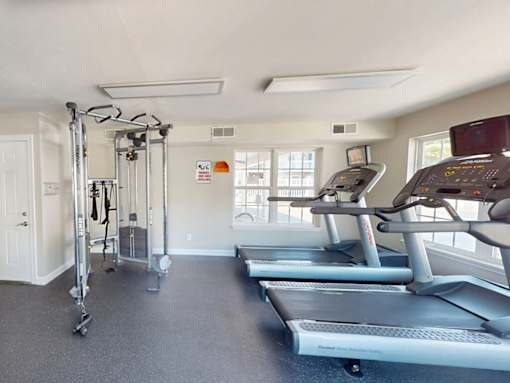 A gym with treadmills, weights, and exercise equipment.