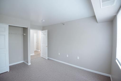 A large empty room with a doorway leading to another room.