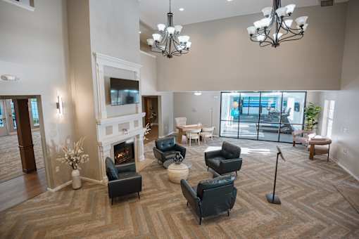 A large, well-lit room with a fireplace and comfortable seating.