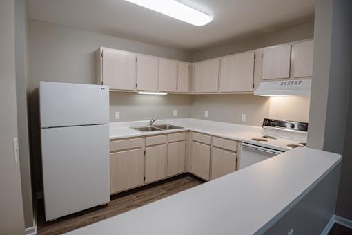 A kitchen with white appliances and cabinets.