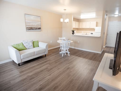 A living room with a white couch and a white chair.