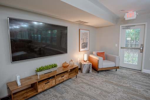 A living room with a flat screen TV mounted on the wall.