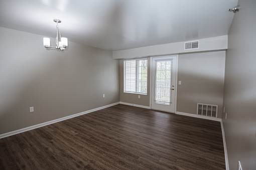 A room with a wooden floor and a chandelier.