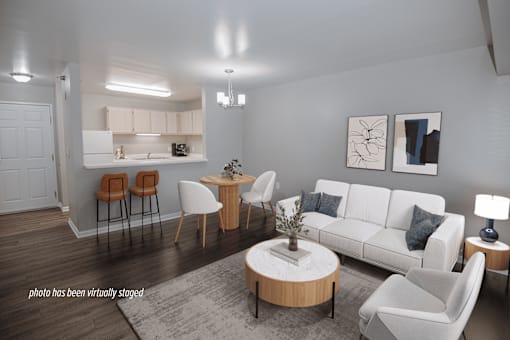 A living room with a white couch, a coffee table, and a dining table with chairs.