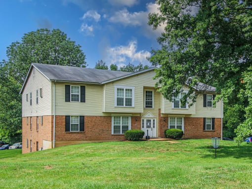 apartment community with a green lawn and trees