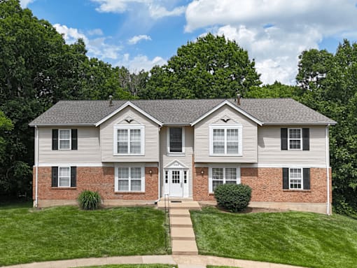 A two-story house with a white door and windows.