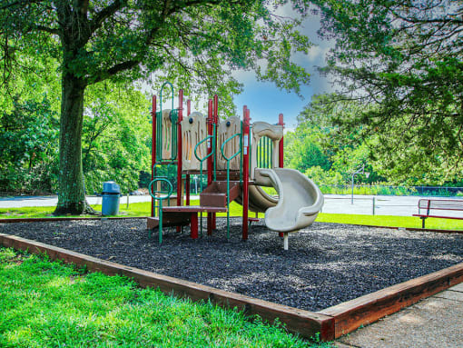 a playground with a swing set and slides in a park