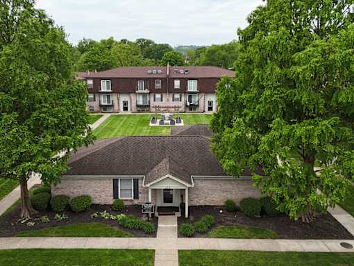 A building with a brown roof is surrounded by trees.