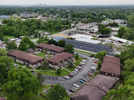 A parking lot is in front of a building with a green lawn.