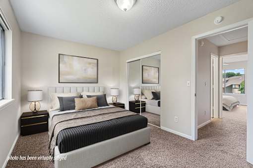 A bedroom with a large bed and a painting on the wall.