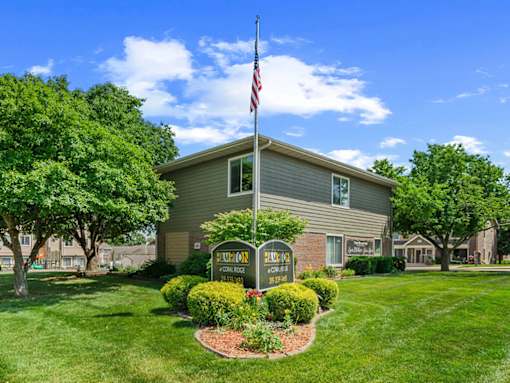 A house with a lawn and a sign that says