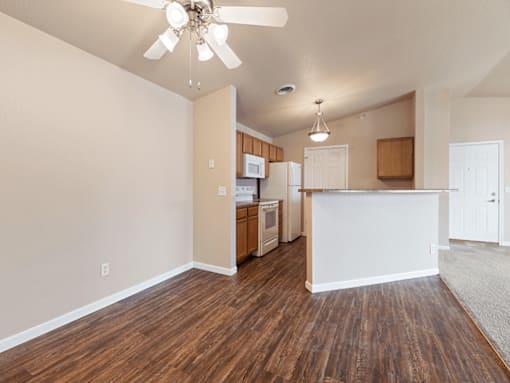 A kitchen with white walls and wooden floors.