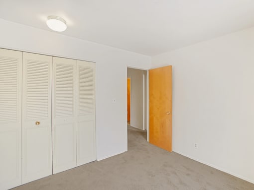 a bedroom with white walls and a wooden door