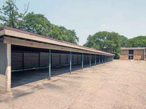 a row of horses stalls with trees in the background