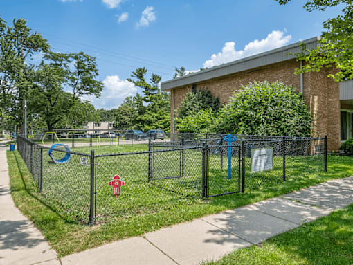 A fenced area with a red stop sign and a blue circular sign.
